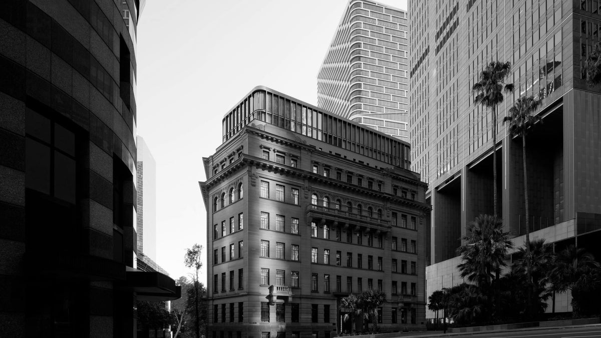 Capella Sydney’s restored sandstone façade framed by central Sydney towers