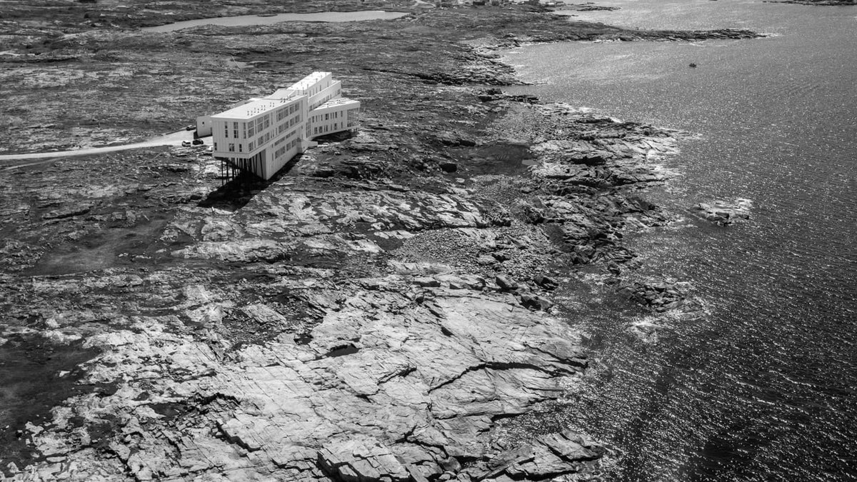Aerial view of Fogo Island Inn above the rocky Newfoundland coastline and North Atlantic
