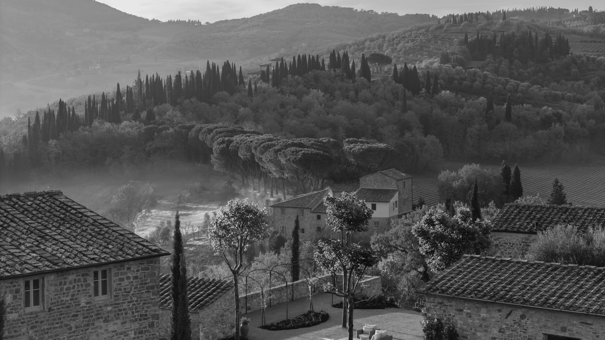 La Darbia Chianti’s restored stone hamlet amid cypress trees and rolling Tuscan hills.