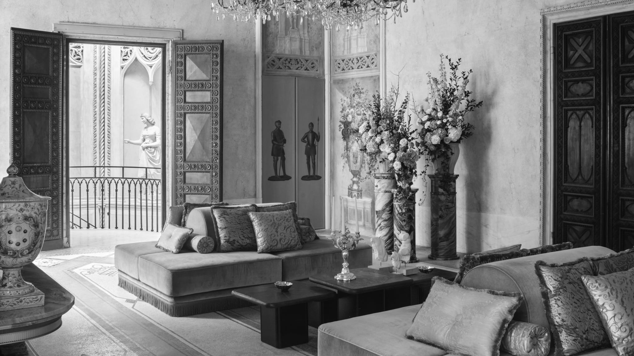 Restored sitting room at Orient Express Venezia, with blue walls, carved doors, chandelier and layered Venetian furnishings.