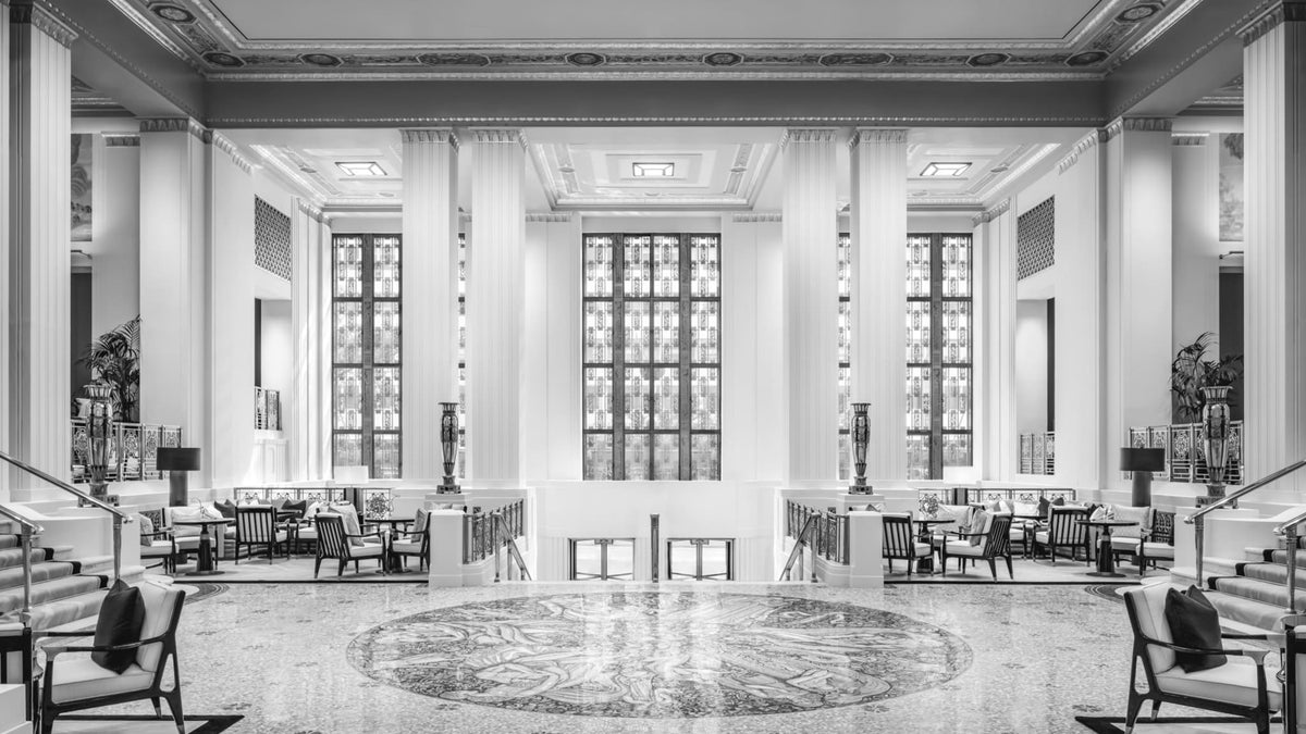 Park Avenue Lobby at Waldorf Astoria New York with lounge seating, white columns and the Wheel of Life mosaic