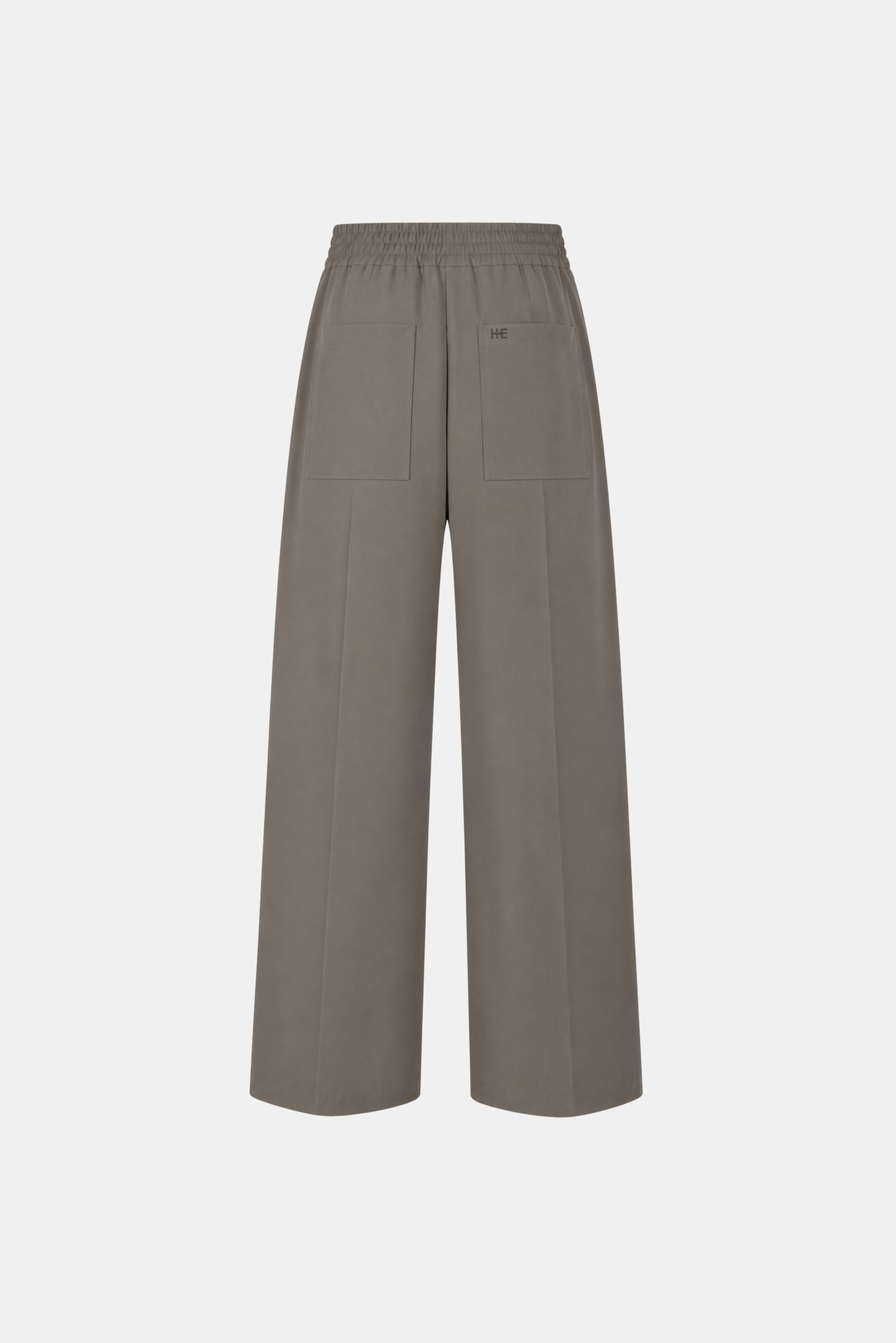 A pair of wide-leg cropped pants in a muted taupe-brown color, featuring an elastic waistband and a small tonal embroidered logo on the upper right leg, shown against a plain light gray background.
