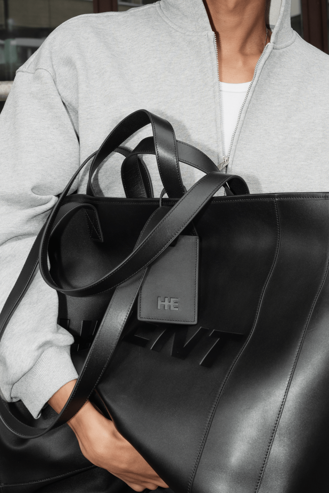 Leather luggage tag made from full-grain bull leather with polished silver hardware and removable raw-edge strap