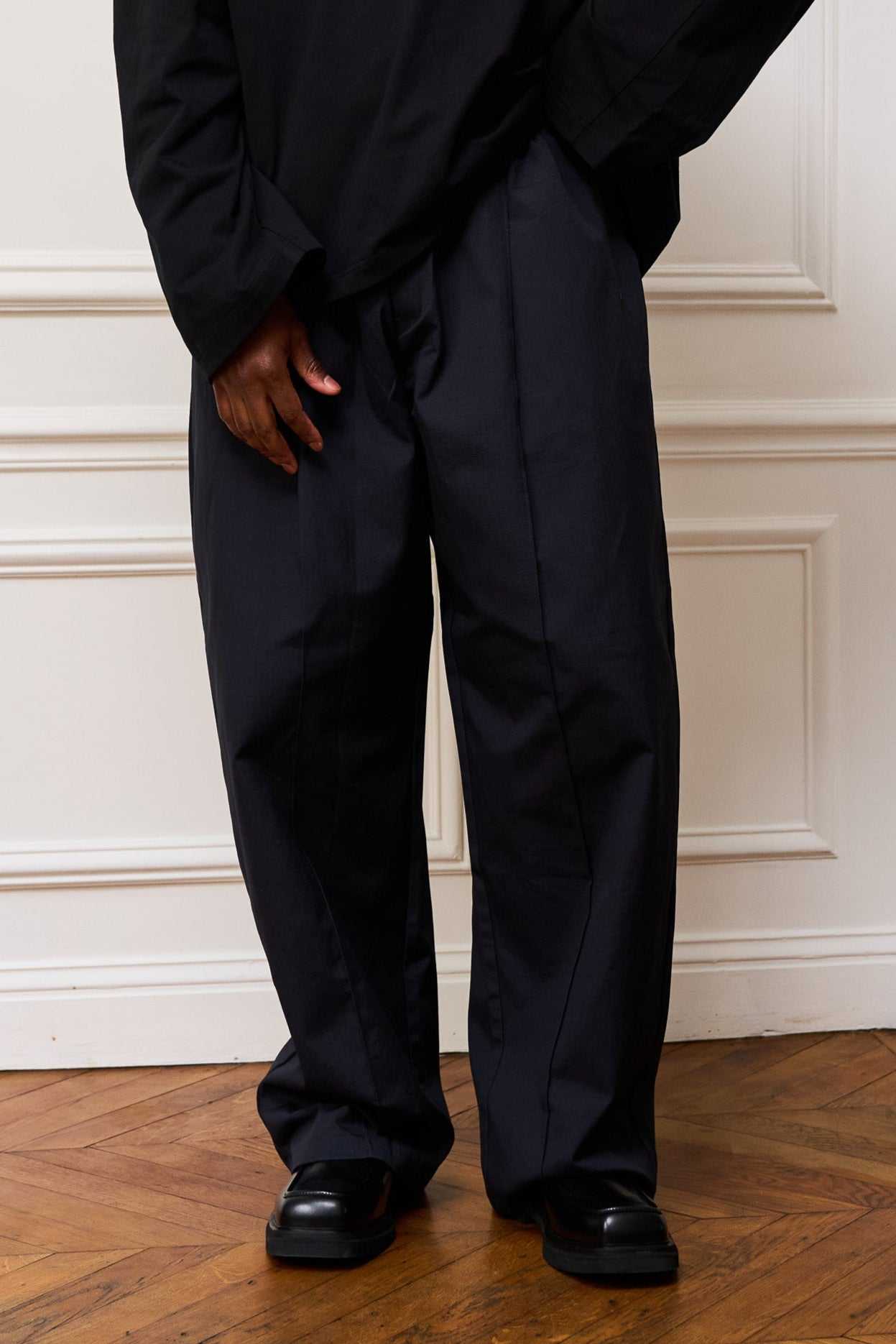 Navy pleated ripstop cotton pants with oversized silhouette and subtle embroidery