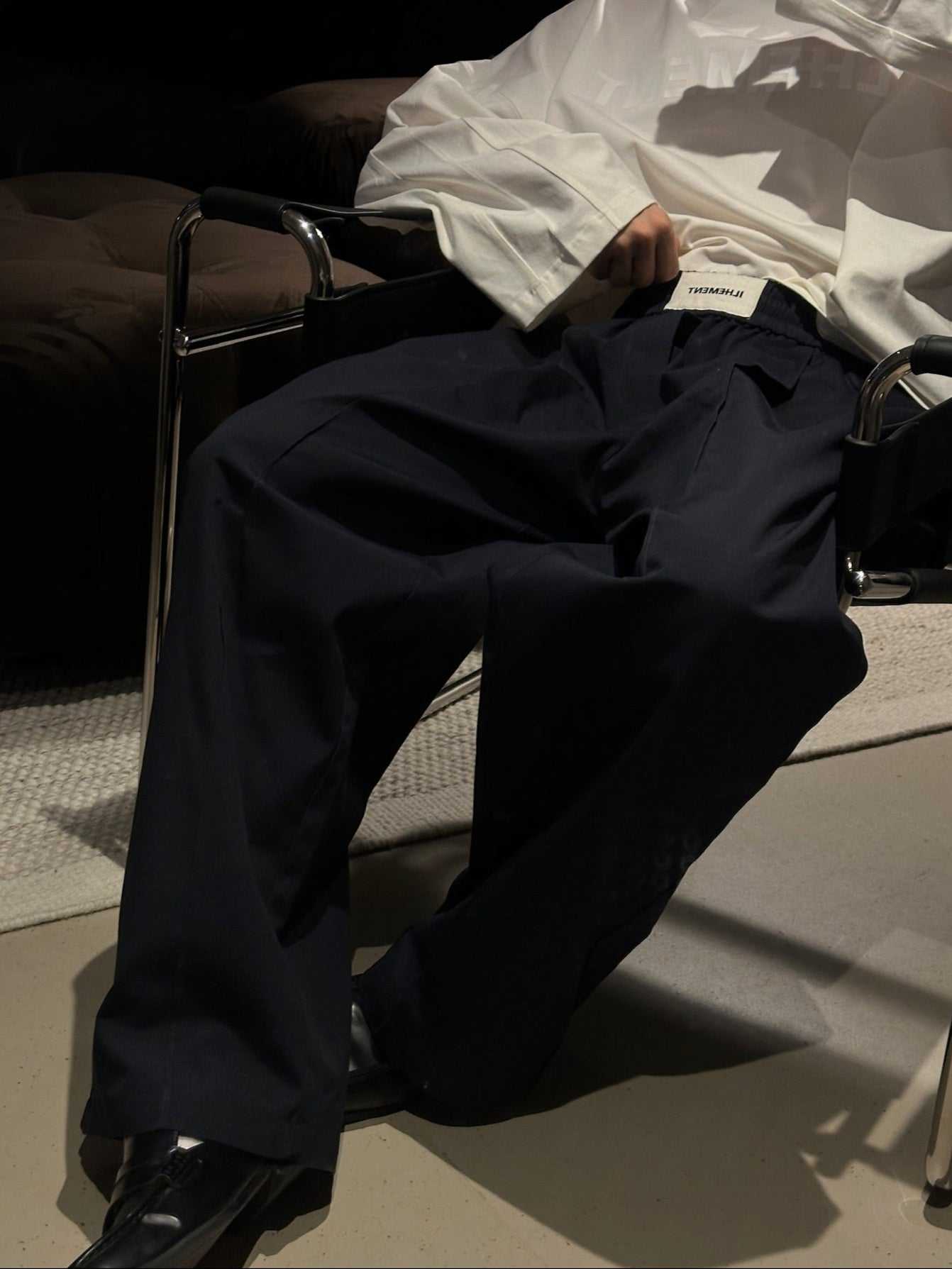 Navy pleated ripstop cotton pants with oversized silhouette and stitched-down front pleats