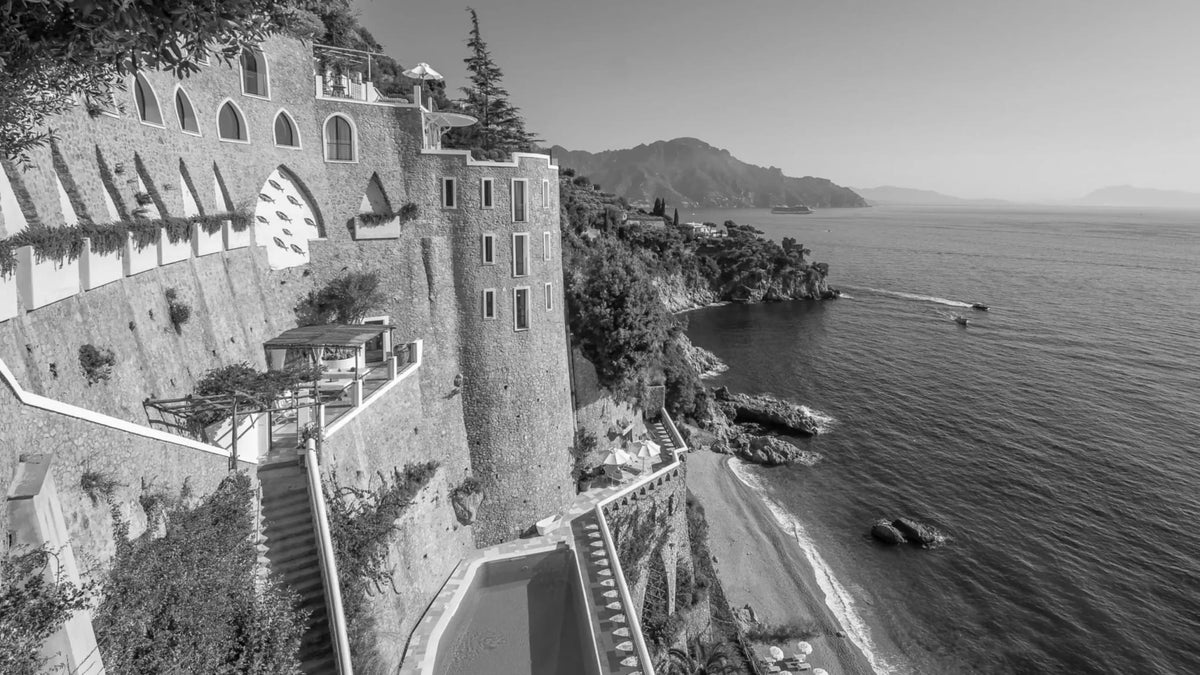 Borgo Santandrea descending through stone terraces towards its private Amalfi Coast beach