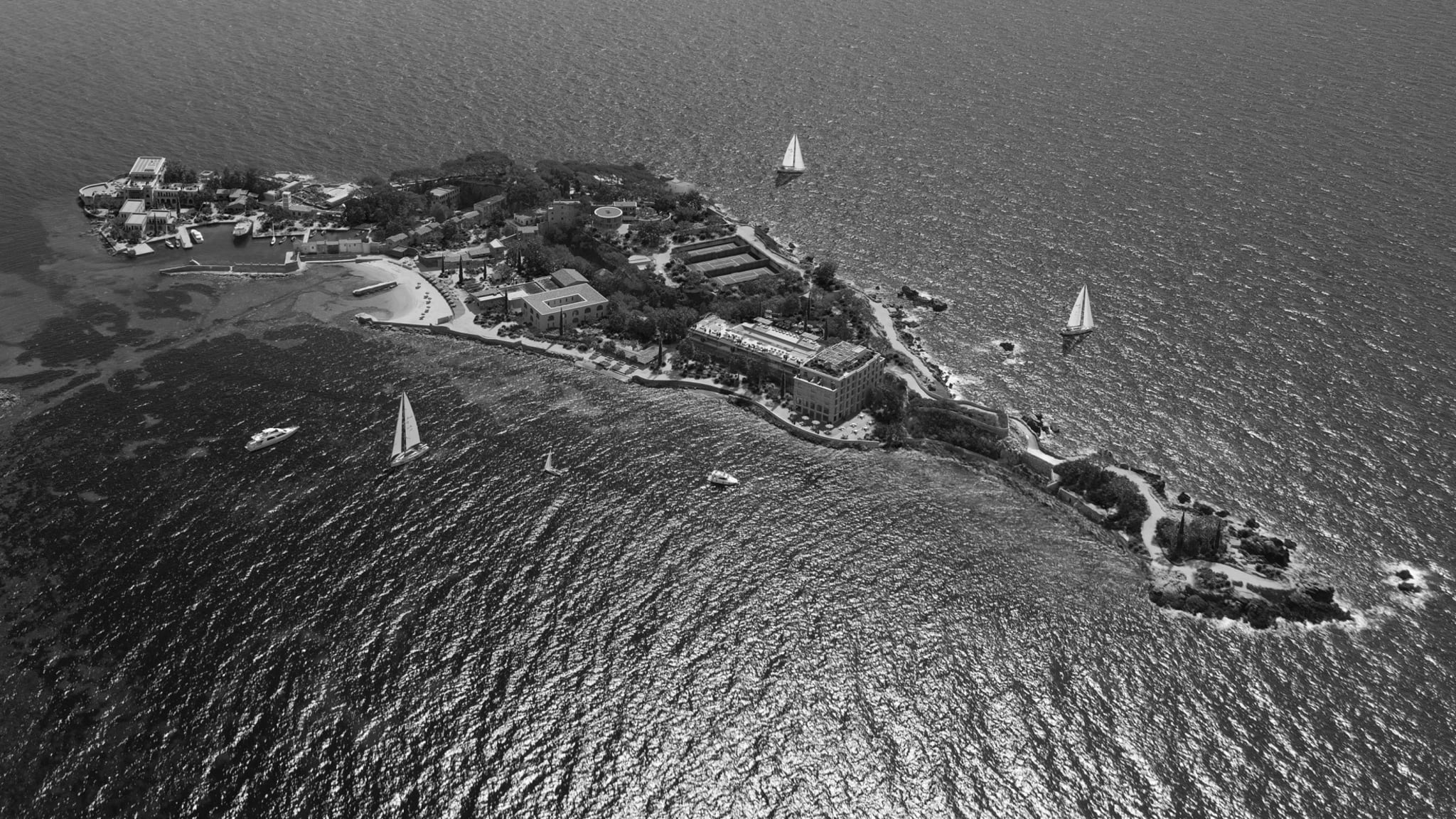 Aerial view of Île de Bendor off the Provençal coast, with restored buildings, pine trees, harbour and Mediterranean sea.