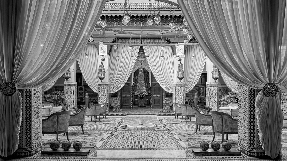 Interior courtyard at Royal Mansour Marrakech with draped colonnades, zellige flooring and carved Moroccan details.
