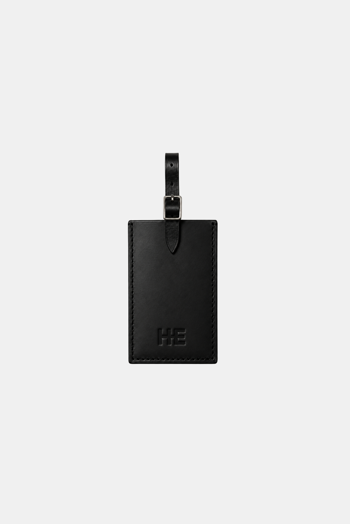 A black leather luggage tag with an embossed logo and a black strap, centered on a light gray background.