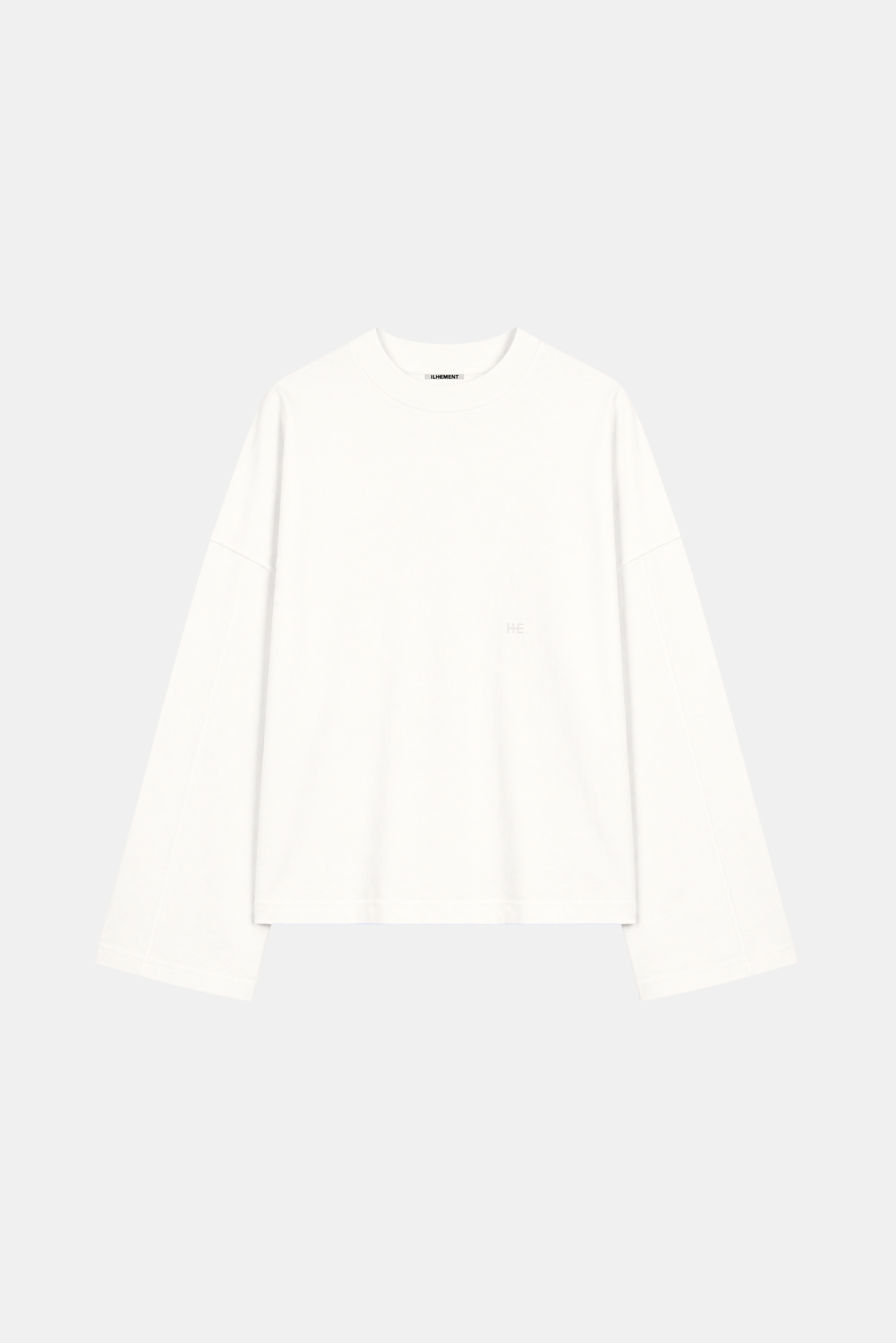 A white long-sleeve crewneck top with a small tonal embroidered logo on the left chest, displayed on a light gray background.