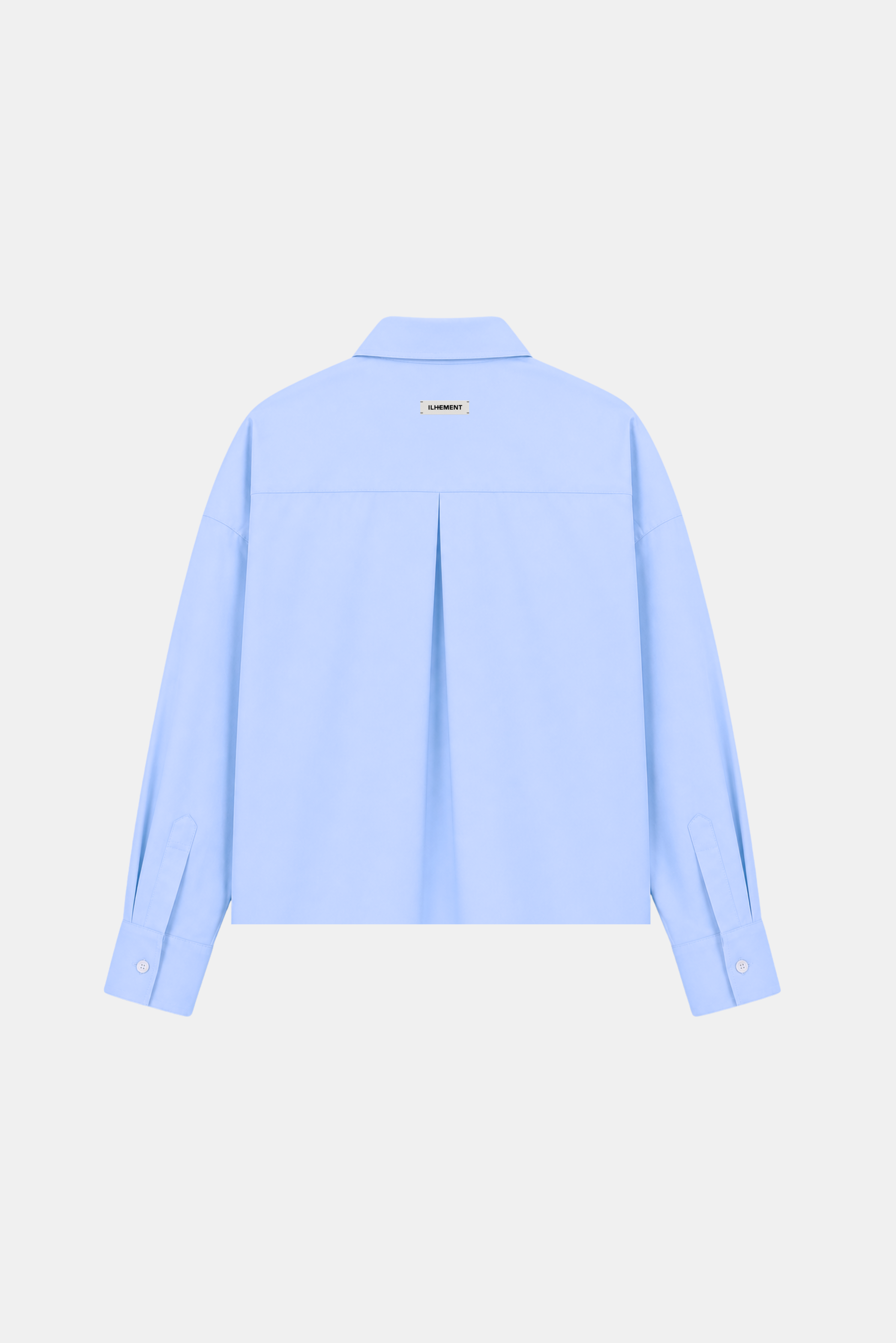 A light blue long-sleeve button-up shirt shown from the back, featuring a subtle vertical pleat down the center back and a small gold rectangular label near the collar, displayed on a clean off-white background.