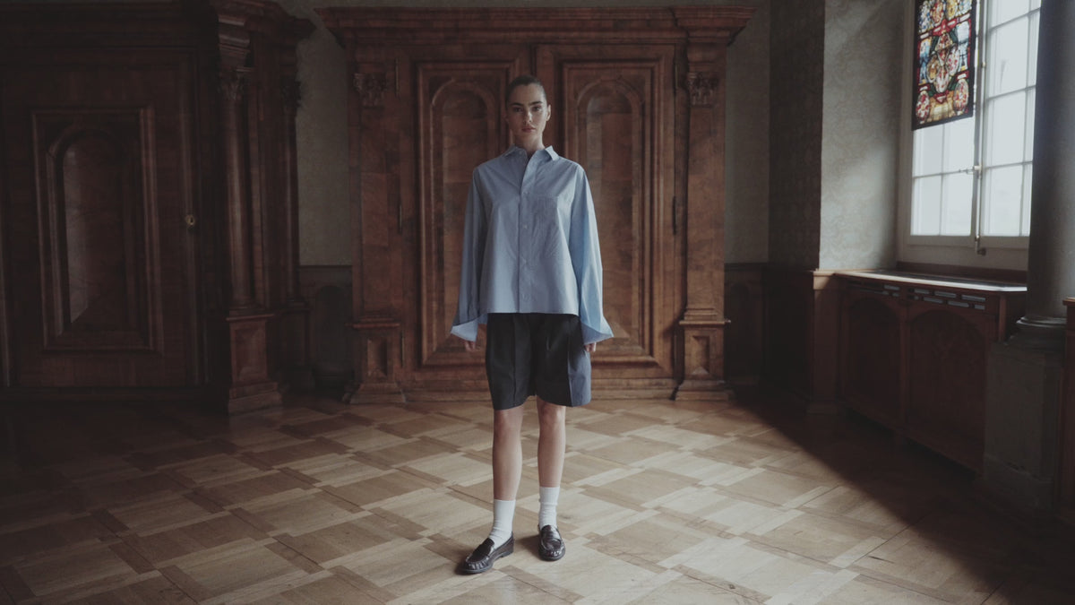 ILHEMENT Swiss resort wear and pyjamas campaign video featuring a woman in pleated boxer shorts and an oversized shirt.